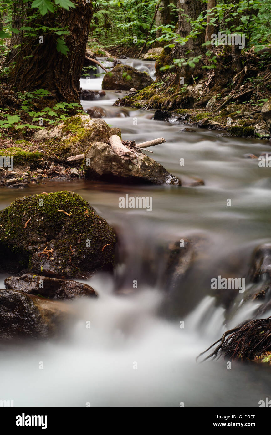 Water flowing in mountain stream - long exposure Stock Photo