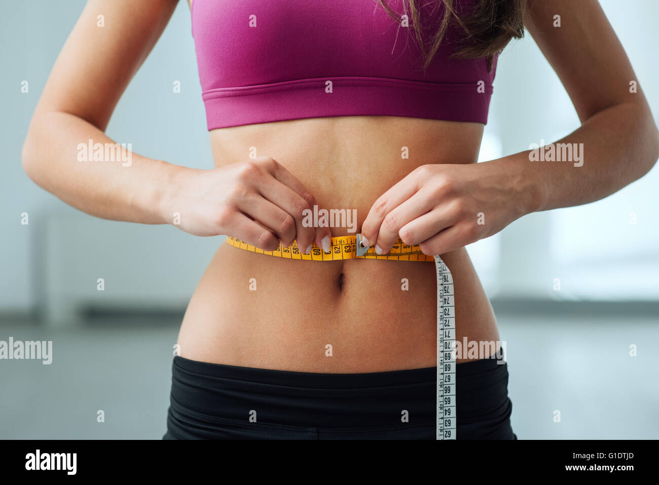 https://c8.alamy.com/comp/G1DTJD/slim-young-woman-measuring-her-thin-waist-with-a-tape-measure-close-G1DTJD.jpg