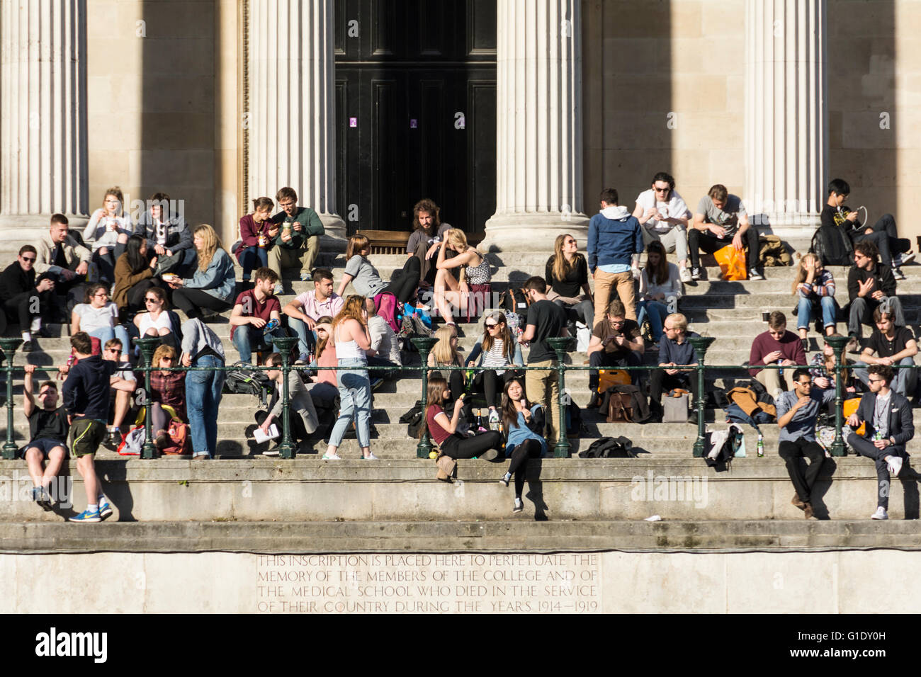 Students sitting on the steps of the Portico and Quad at University College London (UCL), Bloomsbury, London, England, UK Stock Photo