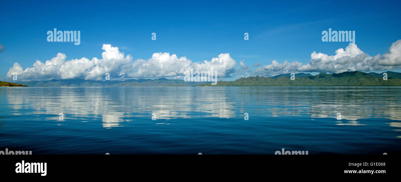 Panoramic view clouds over Komodo reflected in calm sea Komodo National Park Indonesia Stock Photo