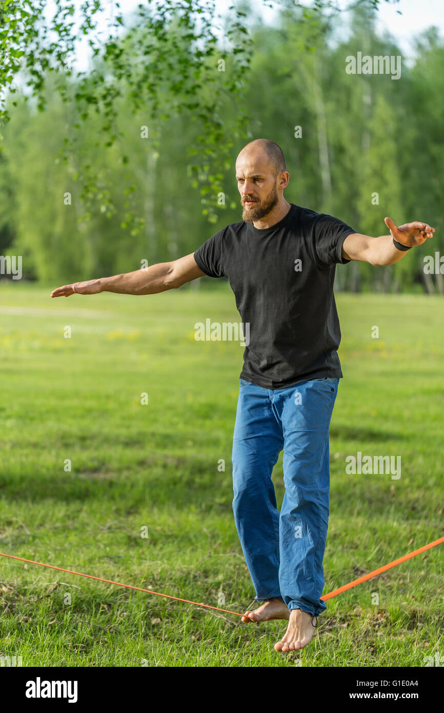 Man practising slack line in the park Stock Photo