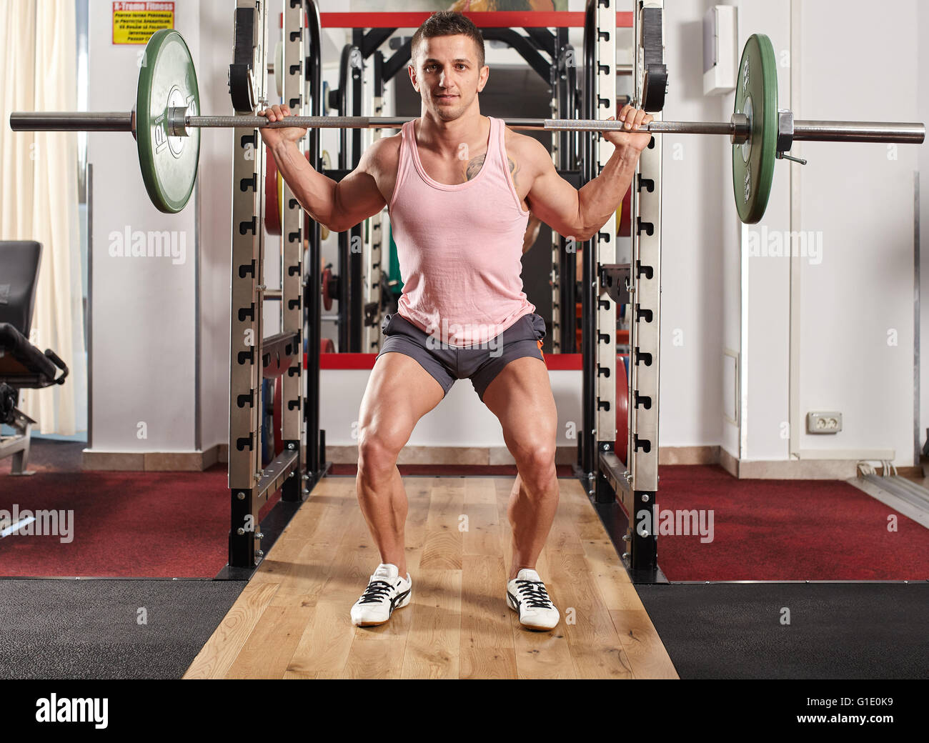 Athletic man doing squats with barbell on neck Stock Photo Alamy