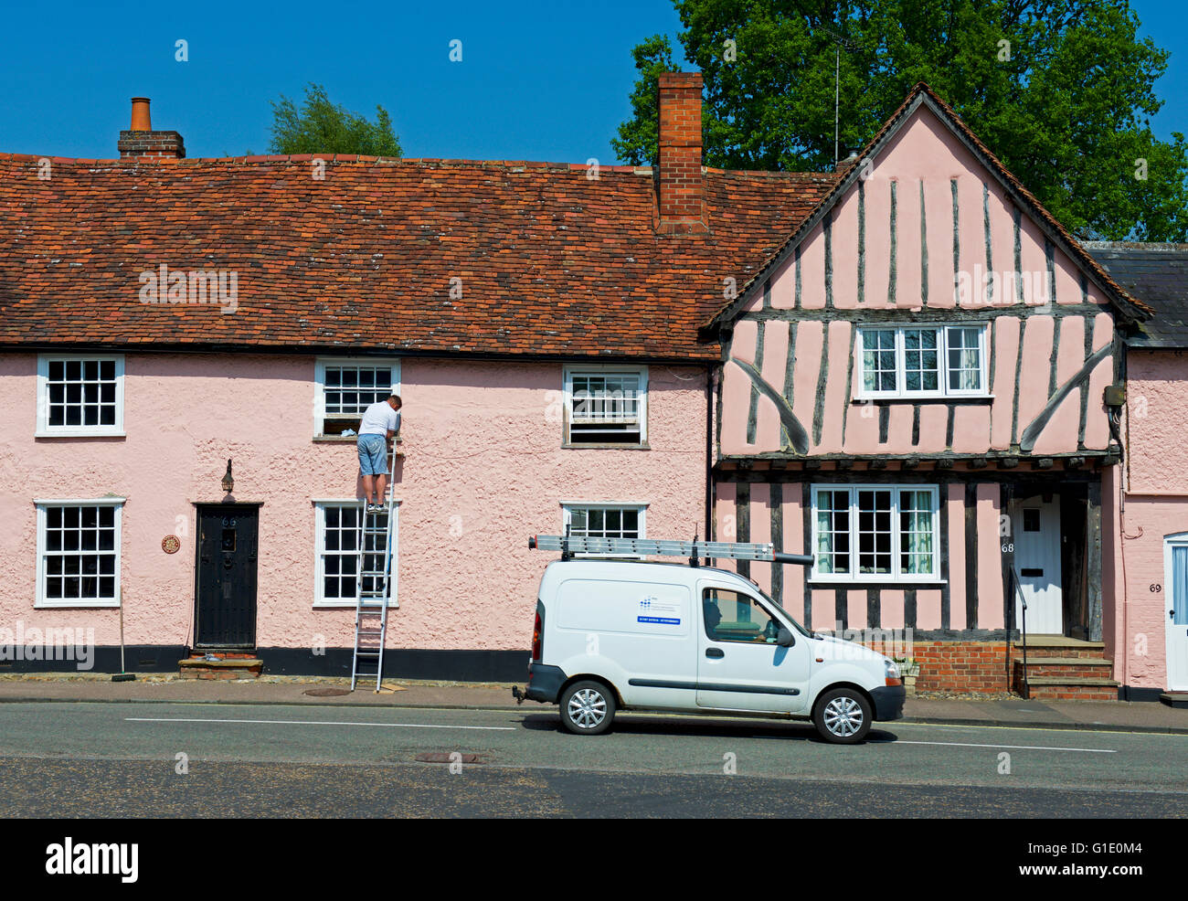 White van passing houses in the village of Lavenham, Suffolk, England UK Stock Photo