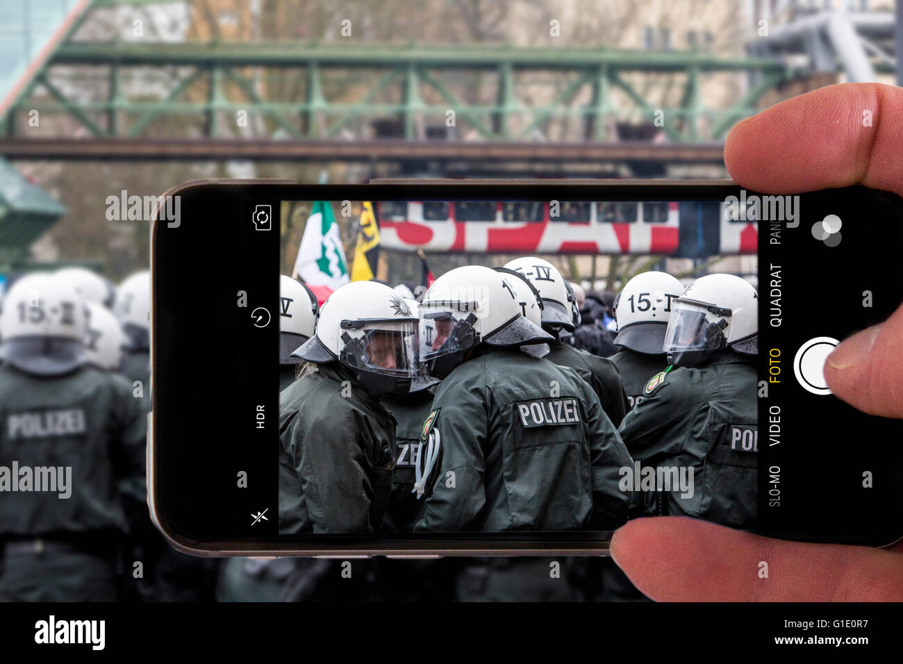 Onlookers take picture with a mobile phone camera, of police operation, symbolic image, photomontage, photo composition, Stock Photo