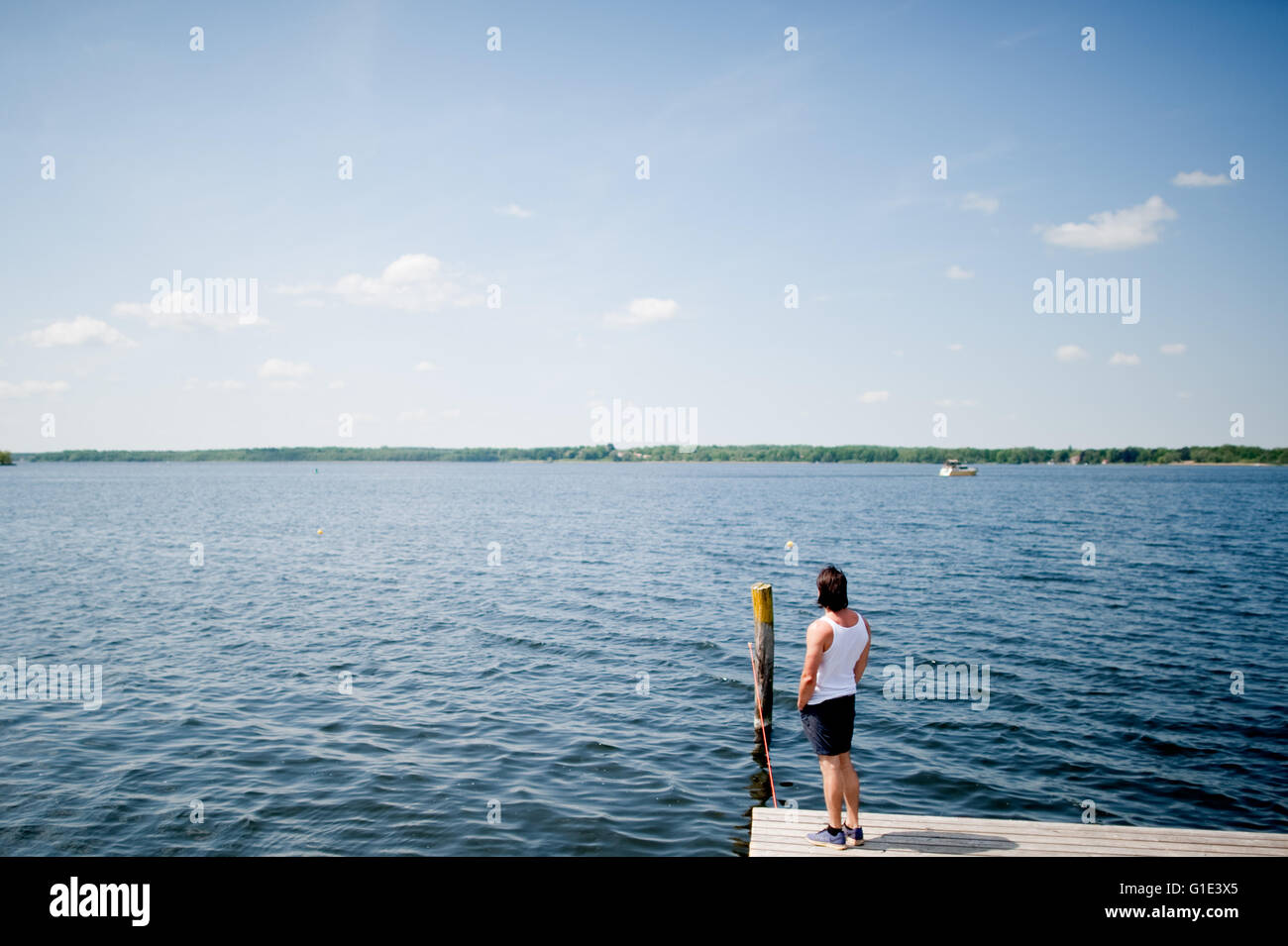 Petzow, Germany. 13th May, 2016. ILLUSTRATION - A man stands on a landing stage at the Caputh lido and looks out onto Lake Schwielowsee in Petzow, Germany, 13 May 2016. The water quality of all 251 official bathing lakes is excellent according to the Ministry of Consumers of Brandenburg. Photo: Klaus-Dietmar Gabbert/dpa/Alamy Live News Stock Photo