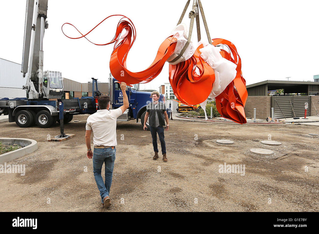 Napa, CA, USA. 11th May, 2016. Phoenix-based artist Pete Deise, right, watches as Andy Byrnes steadies his sculpture before installation at South Napa Century Center on Wednesday morning. The sculpture weighs about 3,500 pounds is 14 feet long by 6 feet high and 28 inches wide. Byrnes is the architect and builder of the center. © Napa Valley Register/ZUMA Wire/Alamy Live News Stock Photo