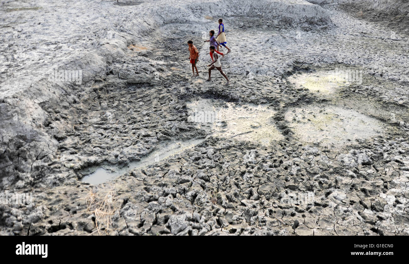 Allahabad, India. 14th May, 2016. Children walk on dry bed of parched River Varuna at Phoolpur. Much of India is reeling from a heat wave and severe drought conditions that have decimated crops, killed livestock and left at least 330 million Indians without enough water for their daily needs. Credit:  Severe drought in India/Alamy Live News Stock Photo