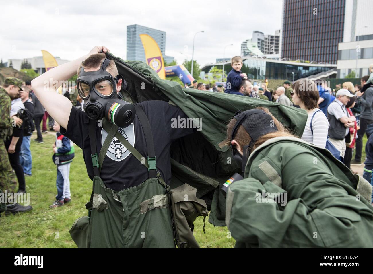 Vilnius, Lithuania. 14th May, 2016. People are trying chemical-proof suits in Vilnius, Lithuania, May 14, 2016. Lithuania celebrates Armed Forces and Public Unity Day in it's captial on Saturday. Troops of Lithuania, Germany, U.S., Luxembourg, Portugal, etc. brought their light weapons, military vehicles and other equipment to the public. Fighting Falcon F-16 of Portuguese air force and Black Hawk of the U.S. air force participated in the performance. Credit:  Alfredas Pliadis/Xinhua/Alamy Live News Stock Photo