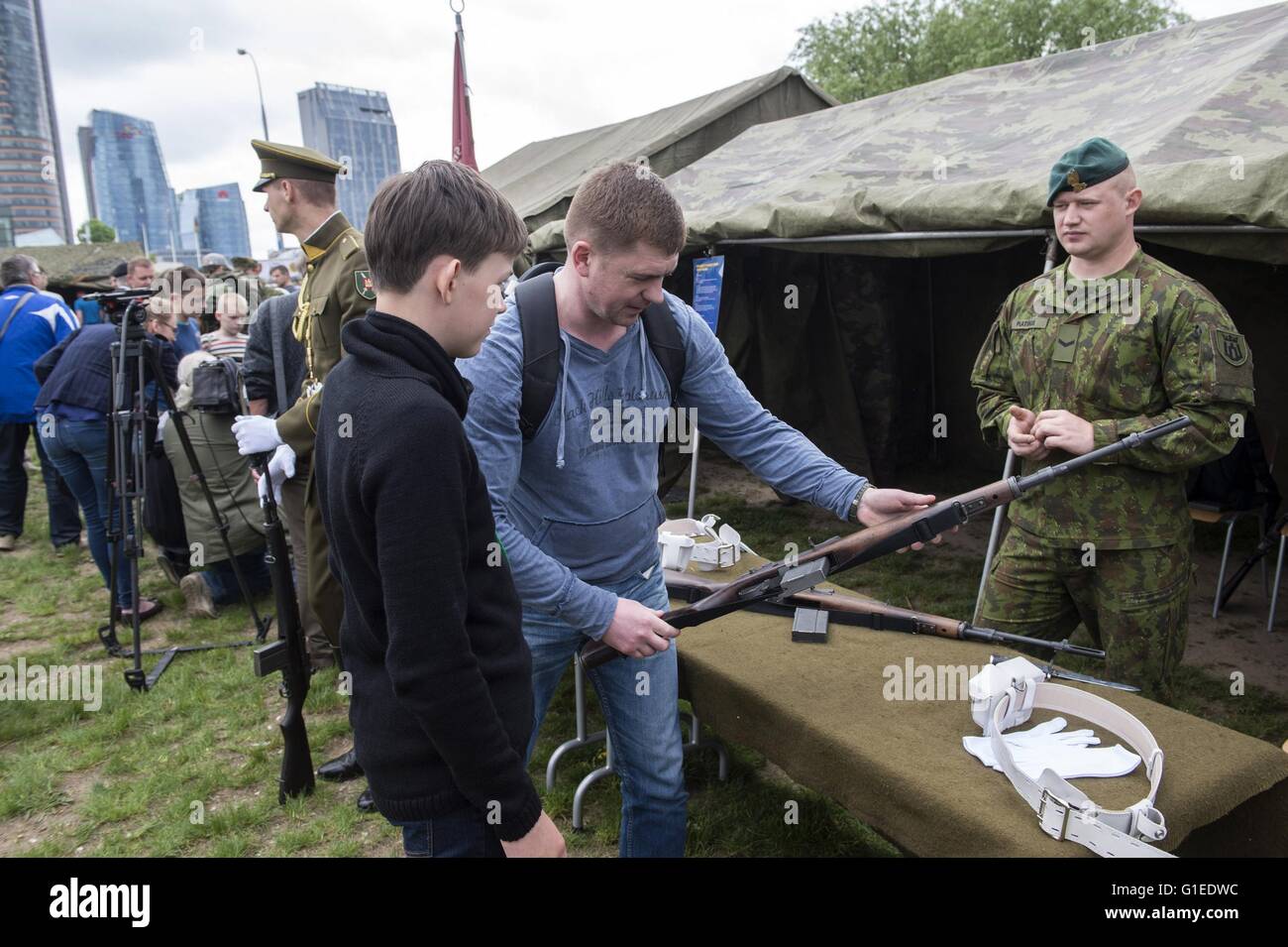 Vilnius, Lithuania. 14th May, 2016. People are viewing weapons in Vilnius, Lithuania, May 14, 2016. Lithuania celebrates Armed Forces and Public Unity Day in it's captial on Saturday. Troops of Lithuania, Germany, U.S., Luxembourg, Portugal, etc. brought their light weapons, military vehicles and other equipment to the public. Fighting Falcon F-16 of Portuguese air force and Black Hawk of the U.S. air force participated in the performance. Credit:  Alfredas Pliadis/Xinhua/Alamy Live News Stock Photo