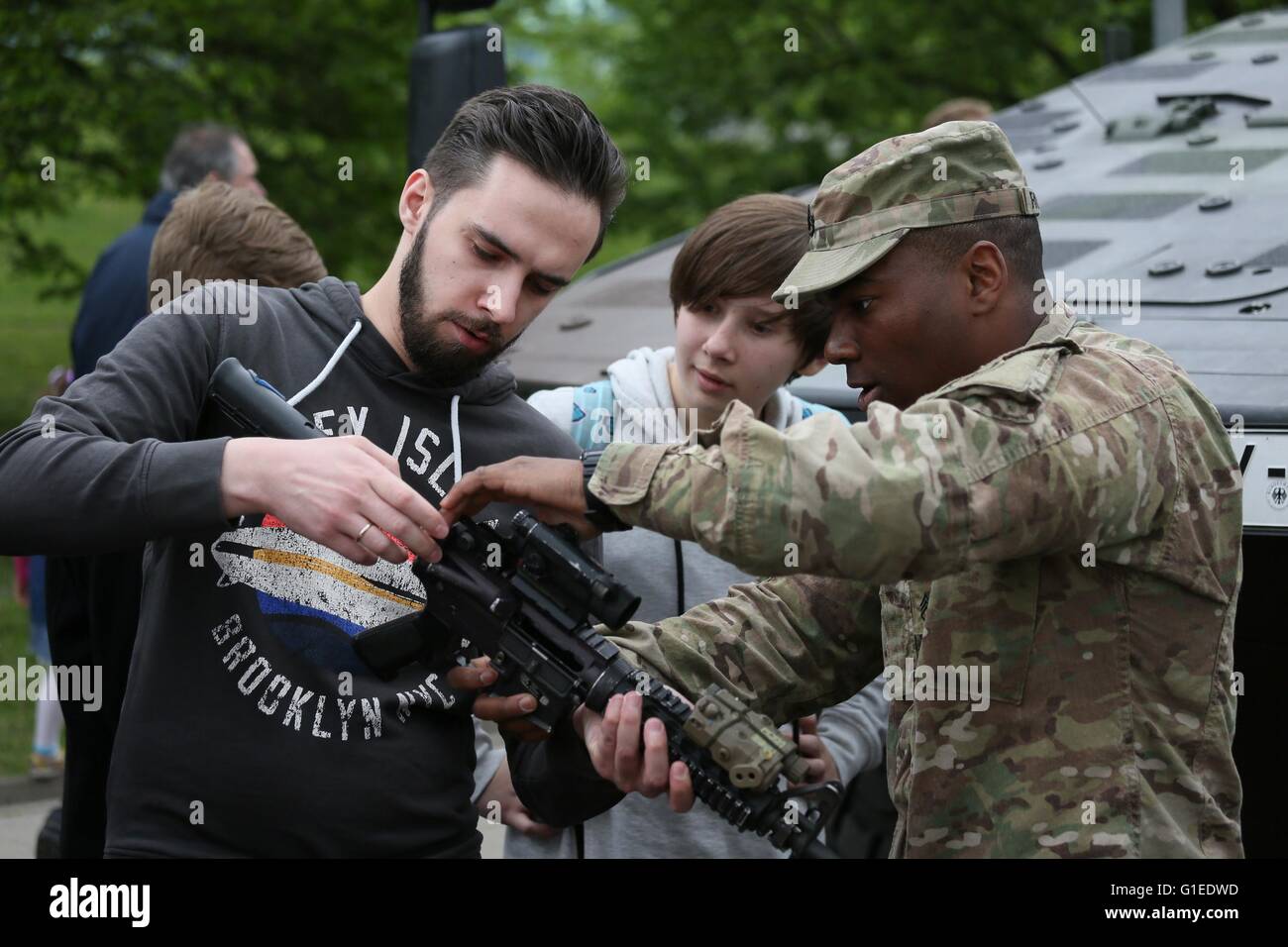 Vilnius, Lithuania. 14th May, 2016. A man is experiencing a weapon in Vilnius, Lithuania, May 14, 2016. Lithuania celebrates Armed Forces and Public Unity Day in it's captial on Saturday. Troops of Lithuania, Germany, U.S., Luxembourg, Portugal, etc. brought their light weapons, military vehicles and other equipment to the public. Fighting Falcon F-16 of Portuguese air force and Black Hawk of the U.S. air force participated in the performance. Credit:  Bu Peng/Xinhua/Alamy Live News Stock Photo