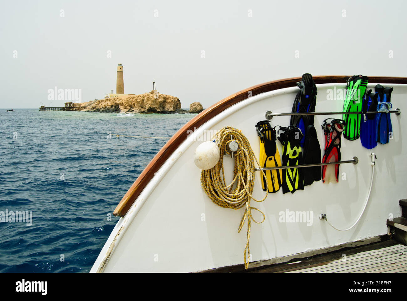 Fins, diving boat and Daedalus lighthouse. Stock Photo