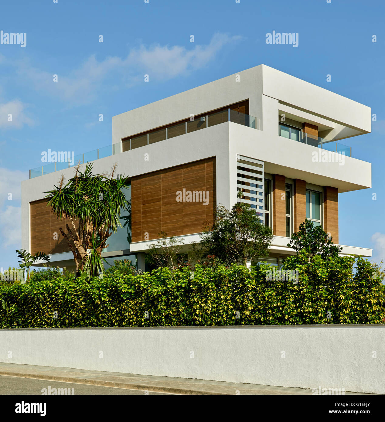 White House, L'Ametlla. Exterior view of the modern house. Partially hidden by shrubs and bushes. Stock Photo