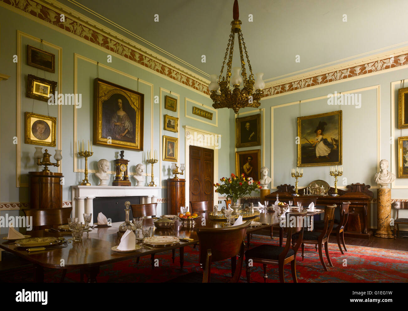Cairness House, Fraserburgh, Aberdeenshire, Scotland. Dining hall with table ready for service and portraits on the wall. Stock Photo