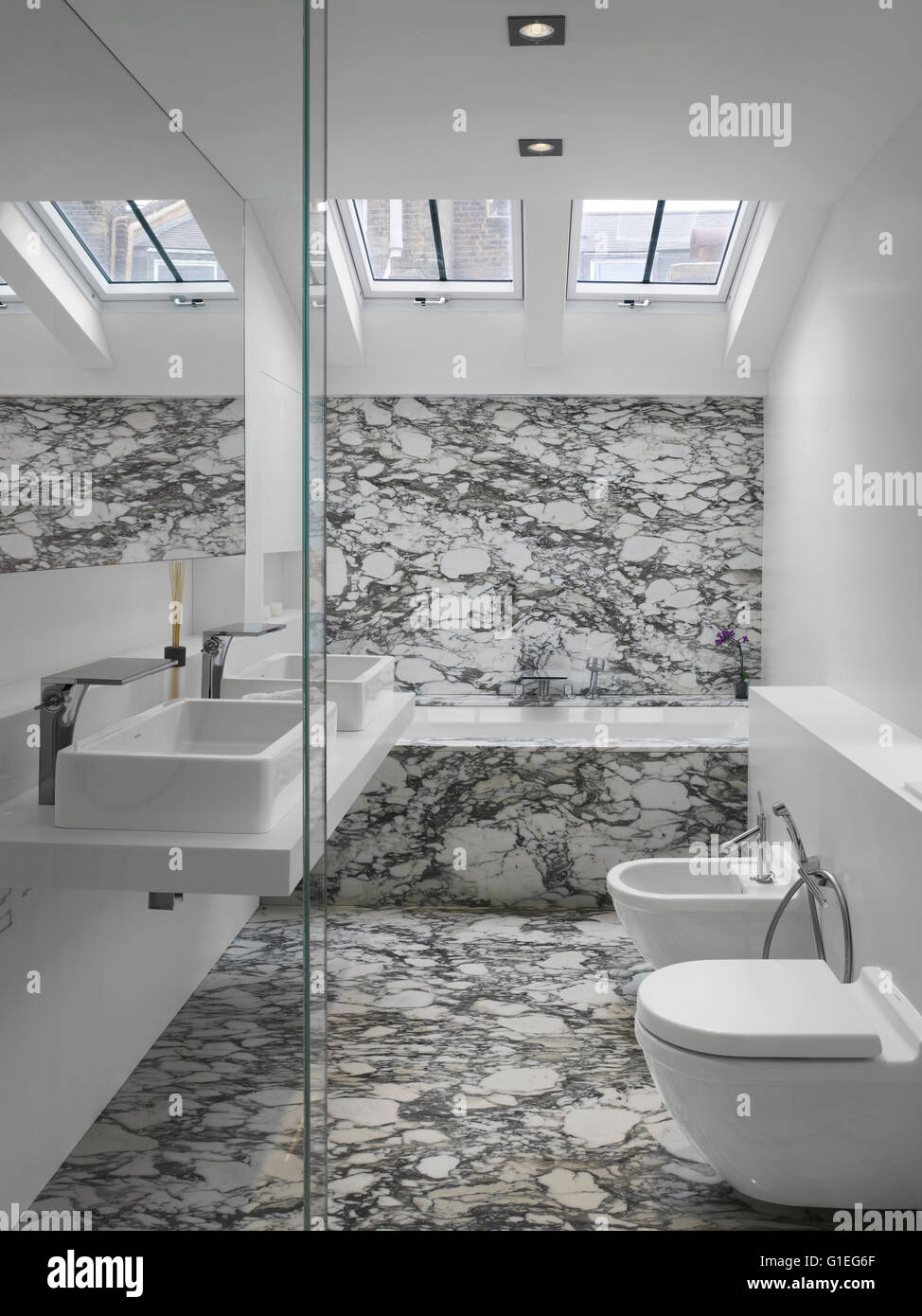 One of a number of bathrooms. Modern bathroom with sleek features and marble walls and floor. Stock Photo