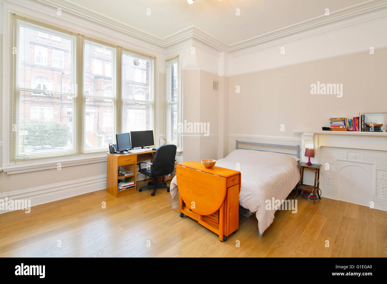 Canfield Gardens, West Hampstead. Bedroom with minimal furniture and contemporary features. Wood floors and large windows. Stock Photo