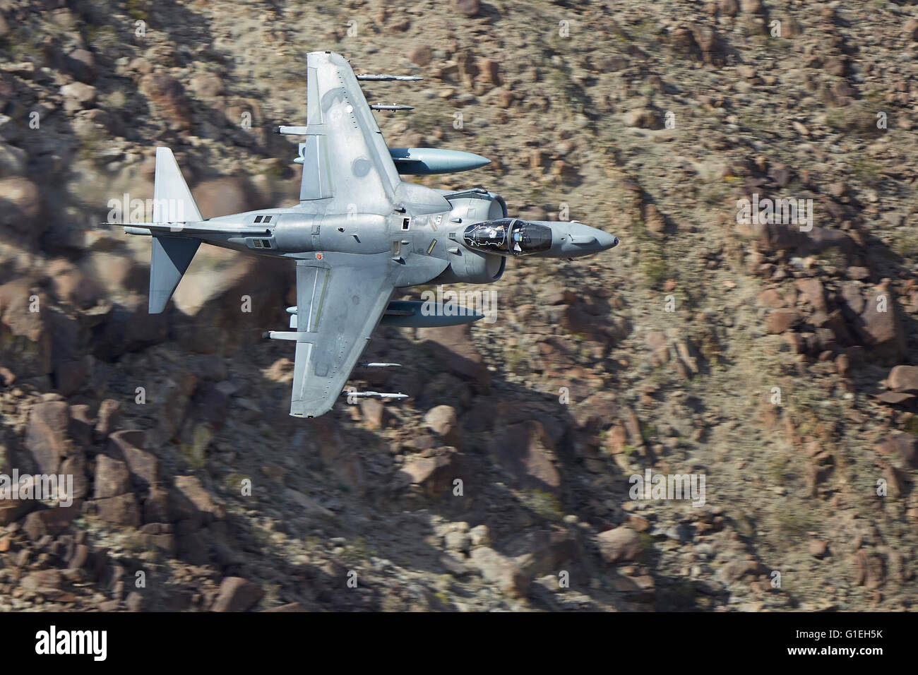 Marine Corps AV-8B Harrier II Jet Flying Low And At High Speed Through A Desert Canyon In California, USA. Stock Photo