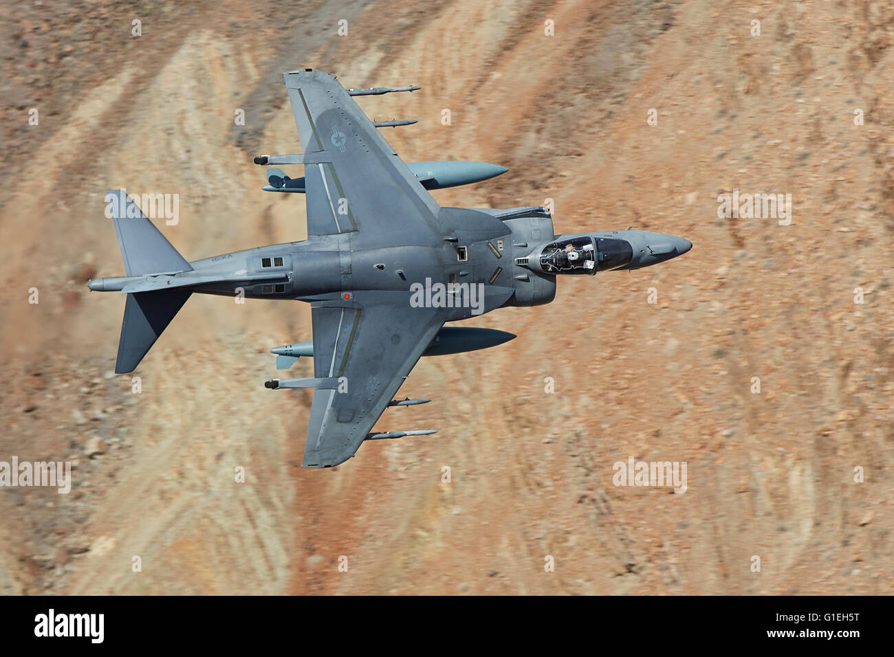 United States Marine Corps AV-8B Harrier II V/STOL Ground Attack Jet Flying At Low Level And High Speed Through A Desert Canyon In California, USA. Stock Photo