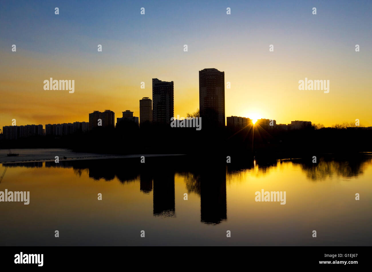 Sunset in the city, reflcting in smooth water. Picture taken in Strogino, Moscow, Russia. Stock Photo