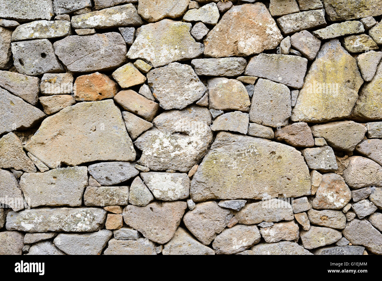 Ancient wall of stones built with blocks of Trachyte and Tuff. Texture Stock Photo
