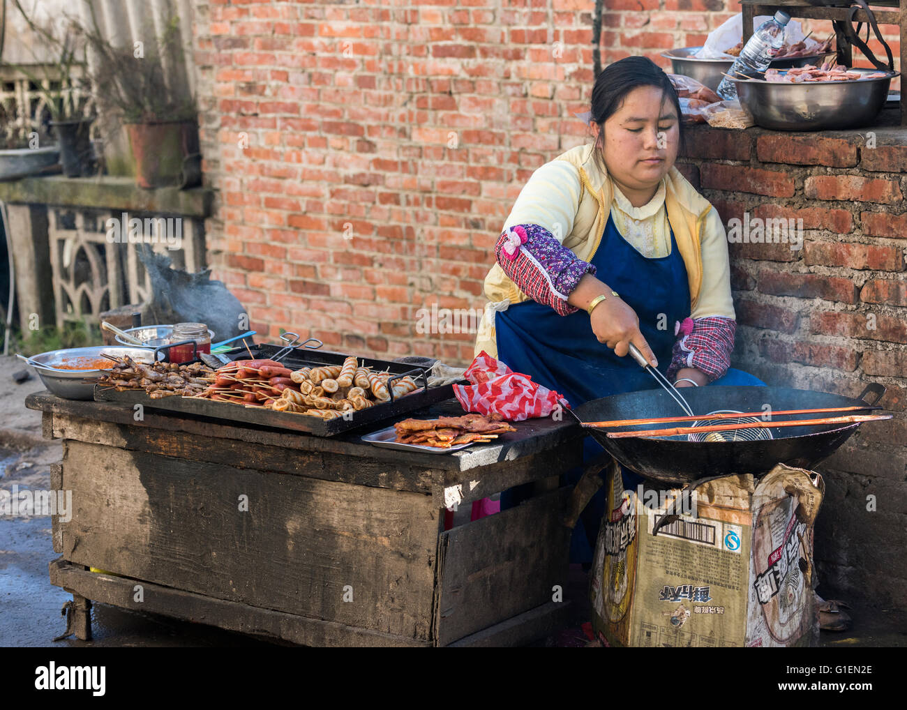 Woman frying street food in a wok, Shengcun market, Yuanyang County ...