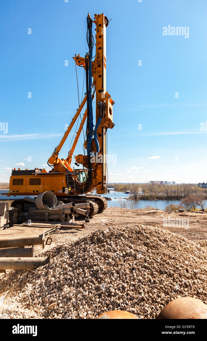 Pile driver at the construction of new Frunze bridge across the Samara river in sunny day Stock Photo