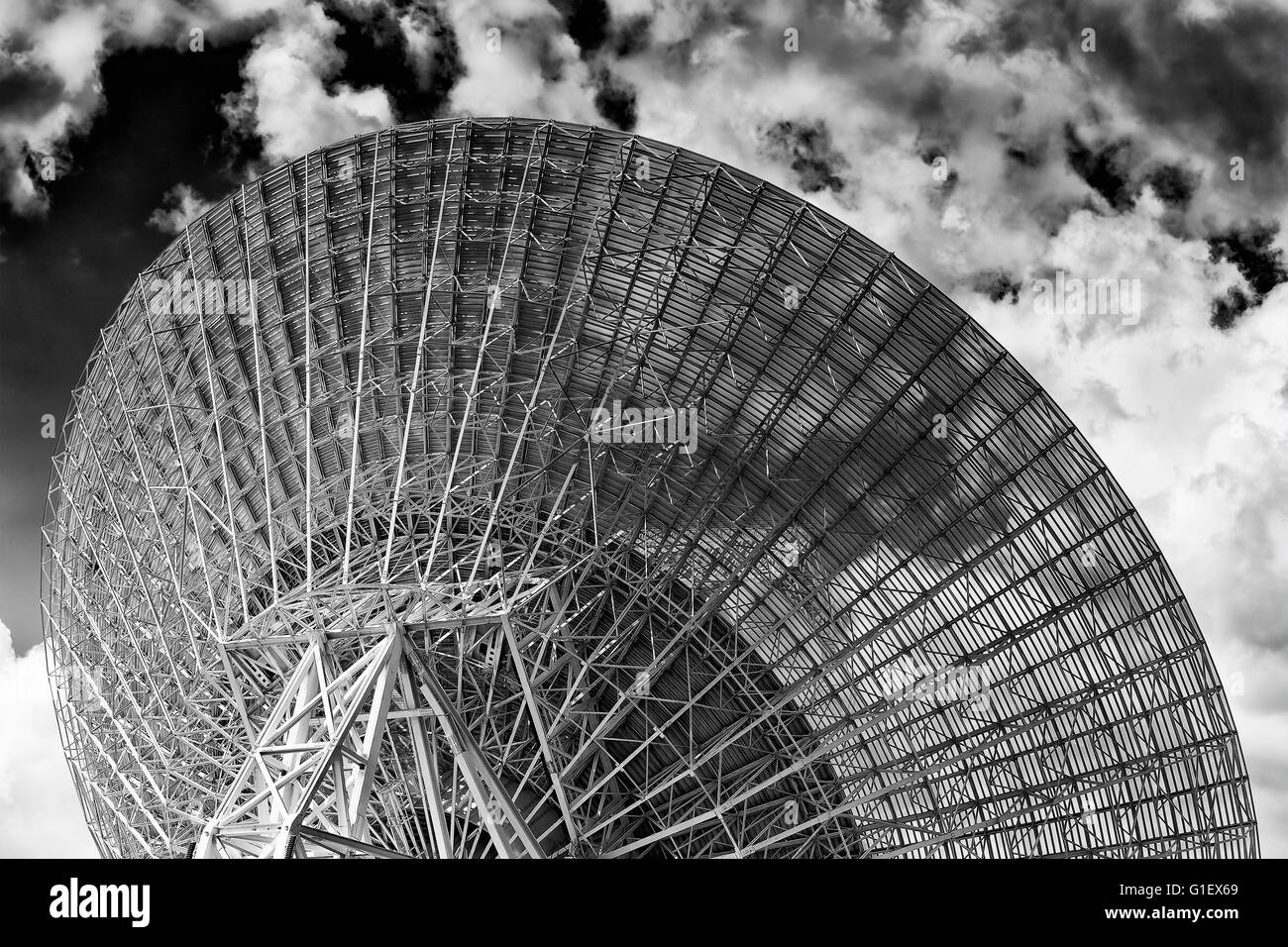 Back of huge radio antenna dish facing cloudy sky in search of space objects as part of CSIRO and NASA communication network. Stock Photo
