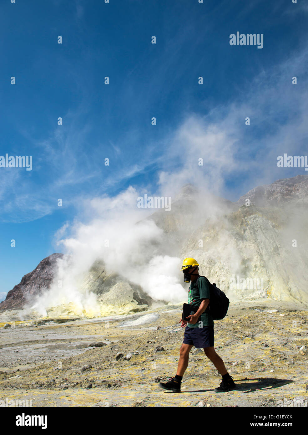 Tourist with gas mask and hard hat on land at active volcano Whakaari White Island New Zealand Stock Photo