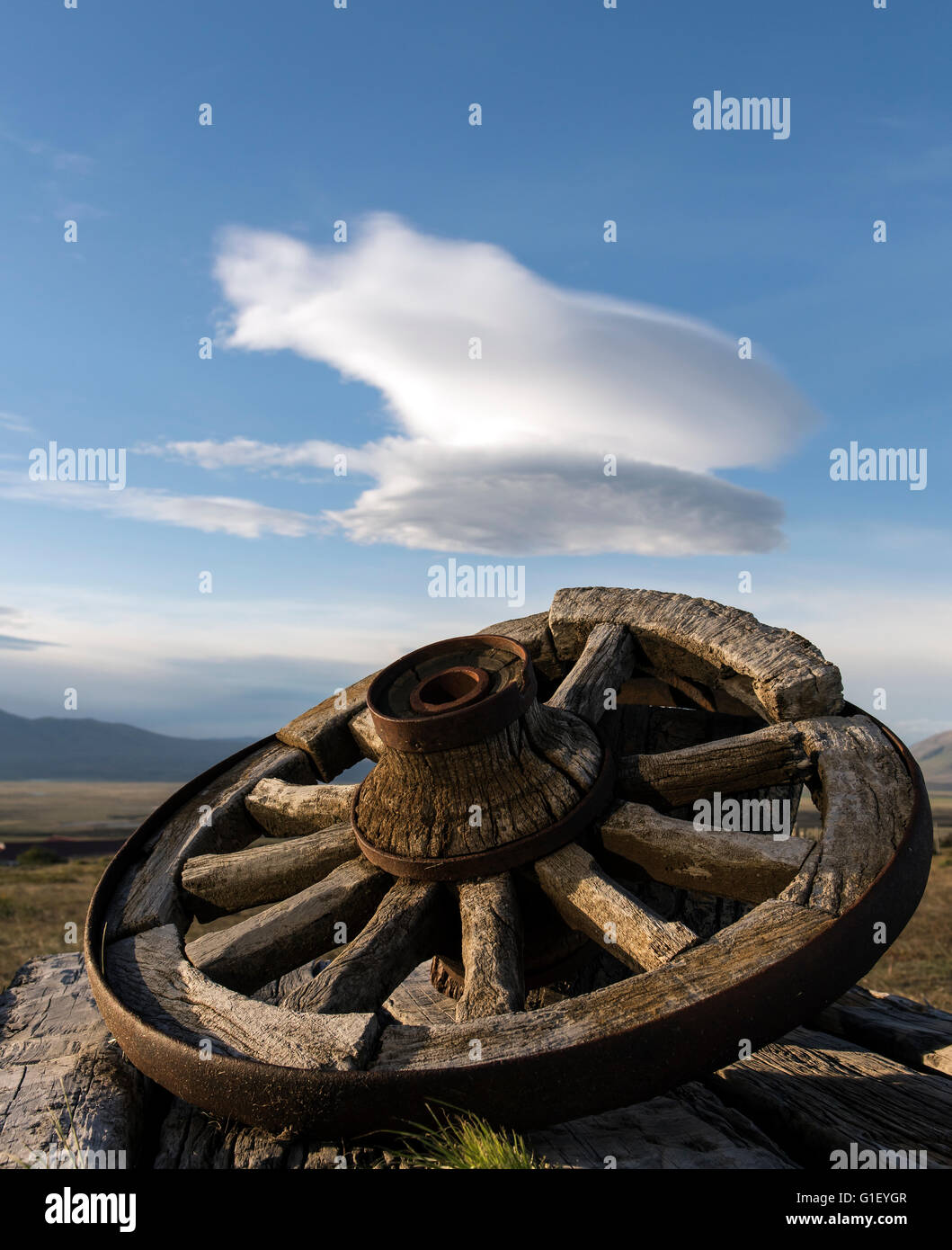 Lenticular clouds (Altocumulus lenticularis) over mountains and wooden-made wheel at Cerro Guido Torres del Paine National Park Stock Photo