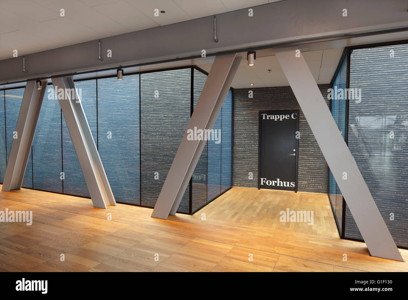 Corridor in top floor administration department, with door, wooden flooring and diagonal supports against panoramic windows. Royal Danish Playhouse, Copenhagen, Denmark. Architect: Lundgaard & Tranberg, 2008. Stock Photo