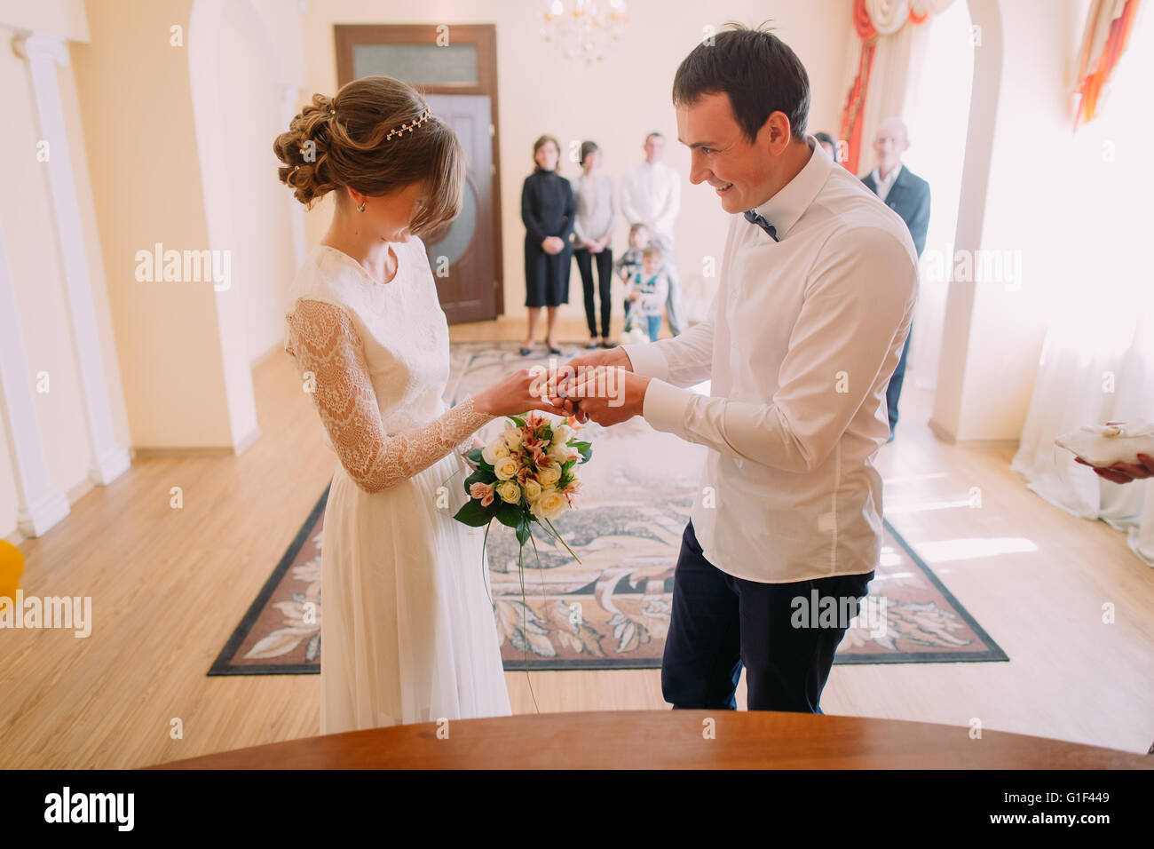 Smiling Bridegroom Putting The Wedding Ring On His Wifes Finger Stock Photo Alamy