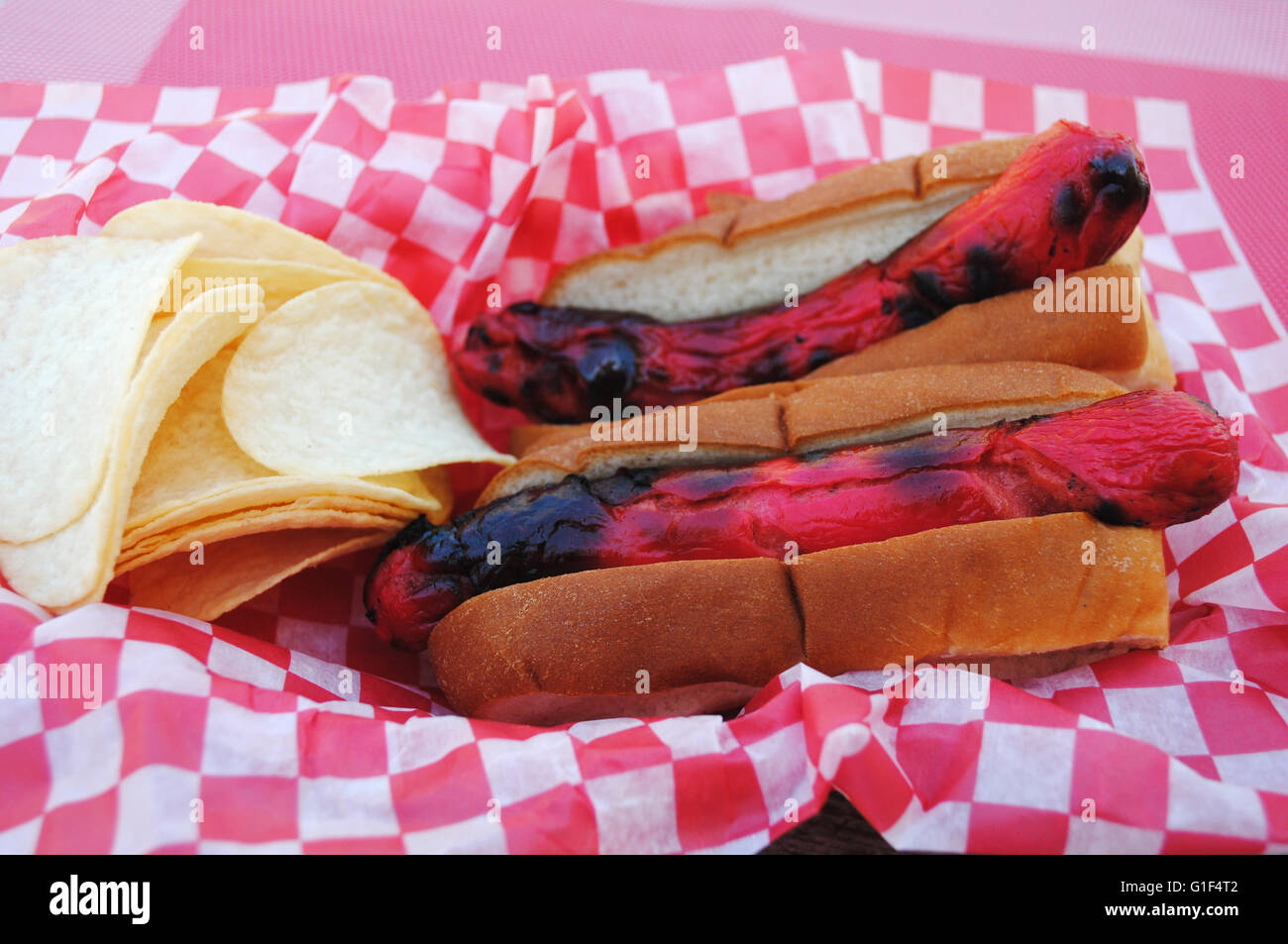 Grilled Hot Dogs Served with Chips Stock Photo