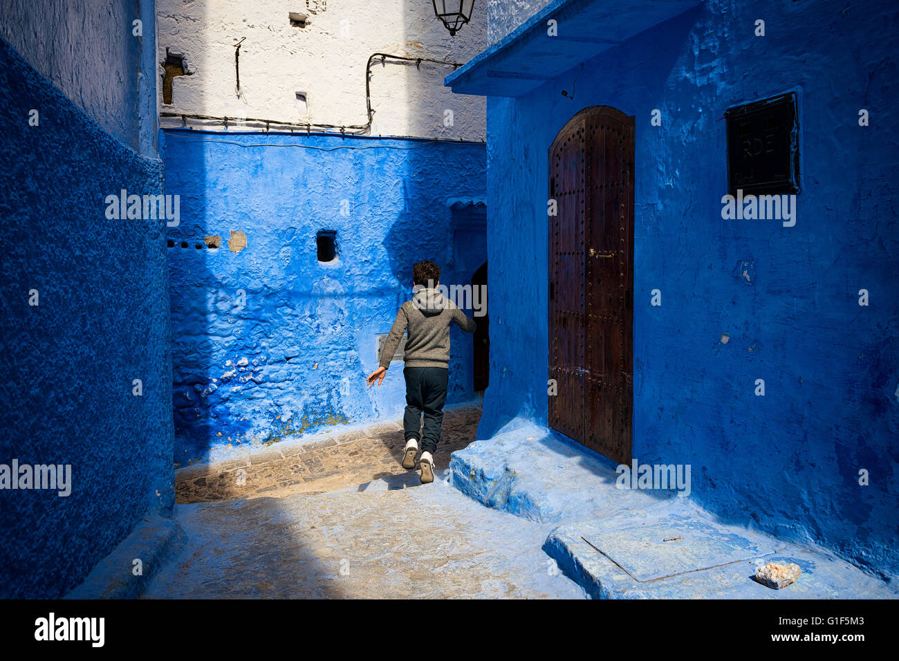 Chefchaouen, Morocco - April 10, 2016: A child running in a street of the town of Chefchaouen in Morocco. Stock Photo