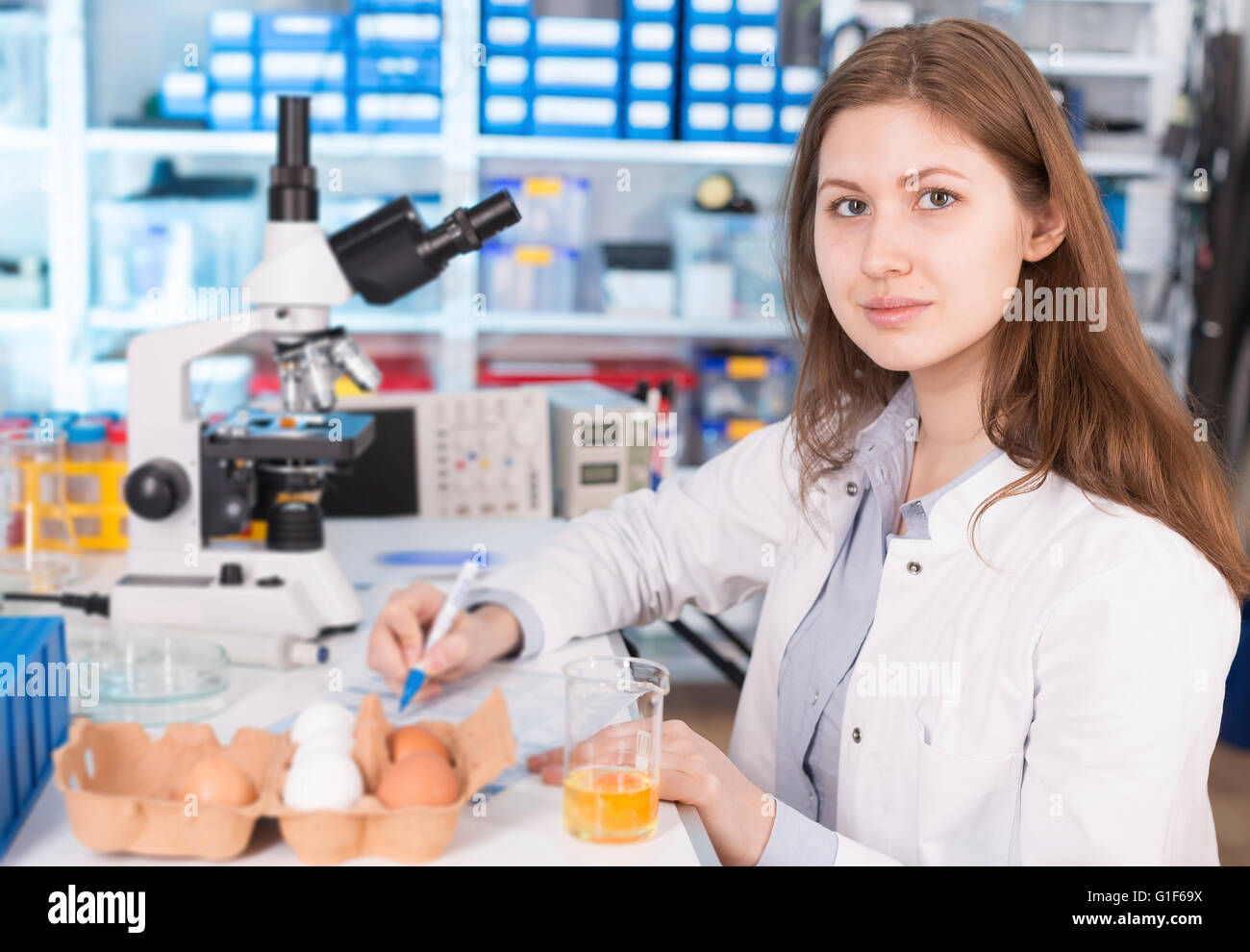 MODEL RELEASED. Female lab technician testing eggs in the laboratory. Stock Photo