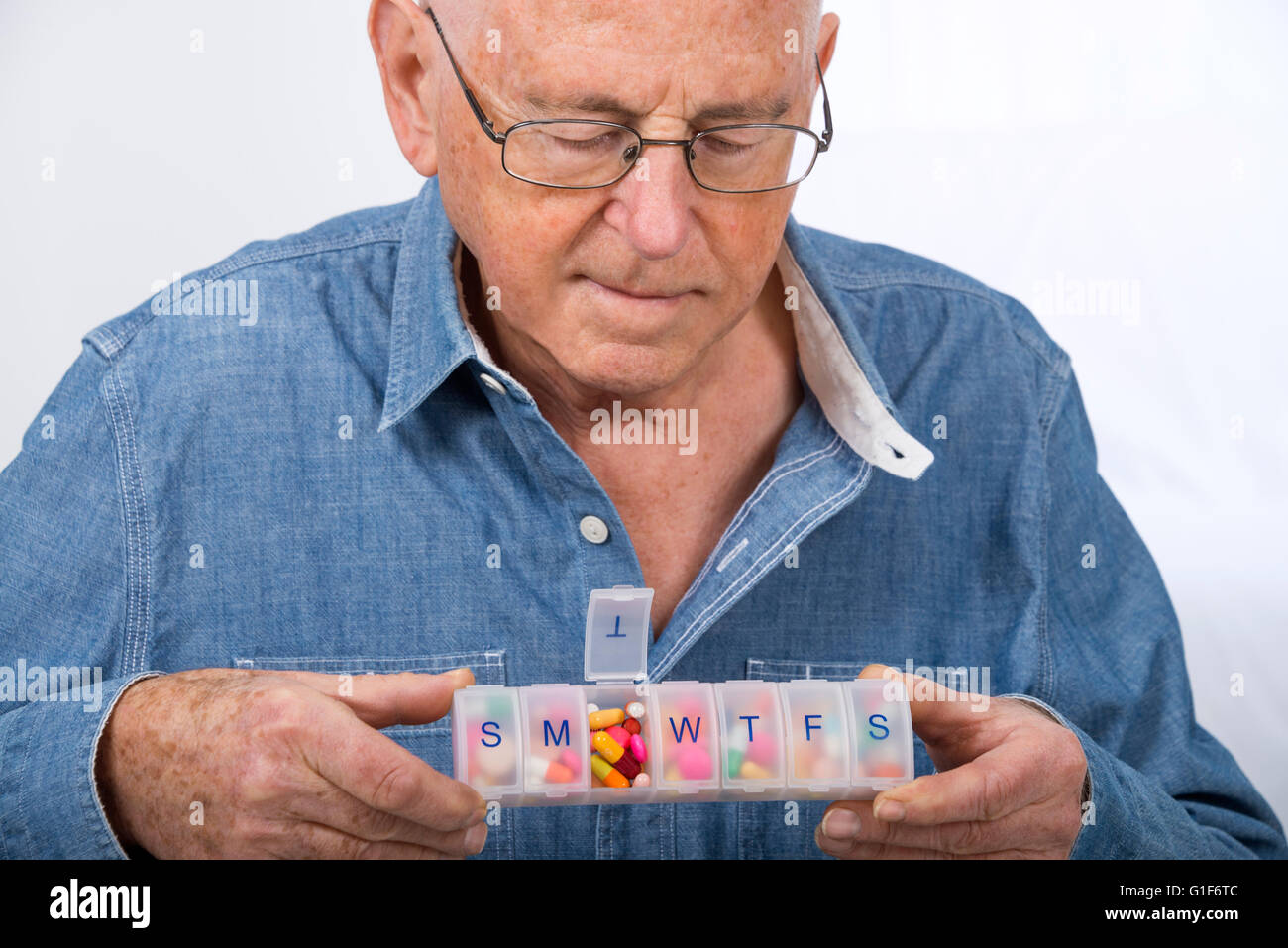 MODEL RELEASED. Senior man holding a pill organiser. Stock Photo