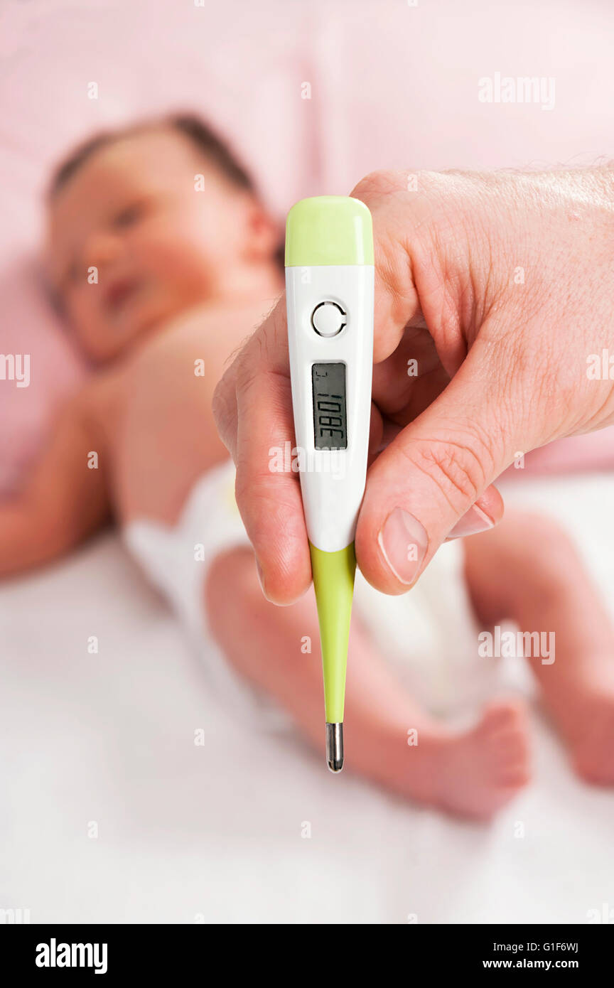 MODEL RELEASED. Parent taking newborn baby's temperature. Stock Photo