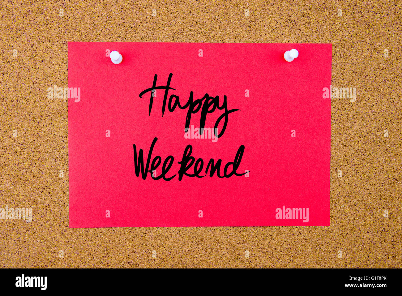 Red paper note with handwritten text Happy Weekend pinned on cork board with white thumbtacks Stock Photo