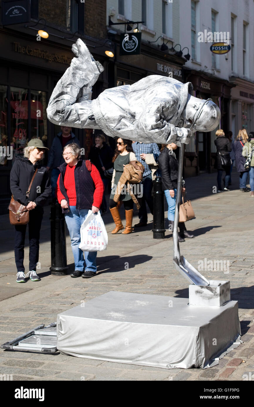 Street Artist Covered in silver dressed as a construction worker Stock Photo