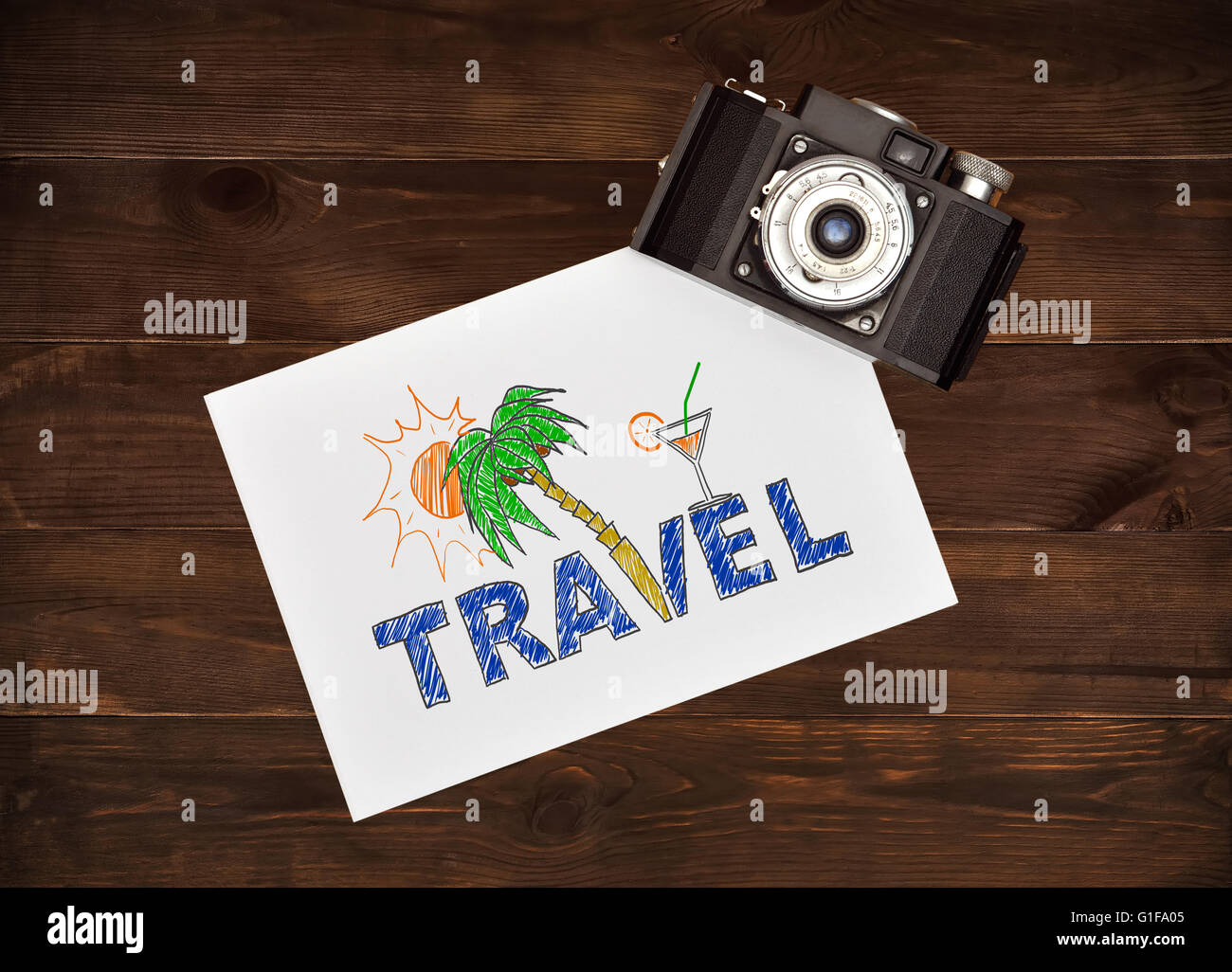 Work desk tourist. Camera and paper with drawing beach holiday concept. Stock Photo