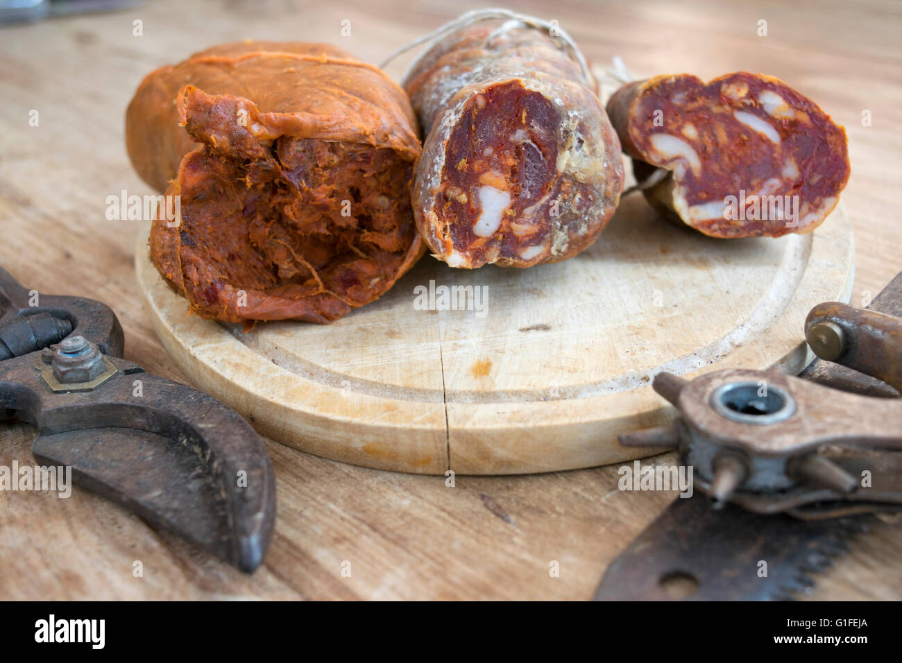 nduja and calabrese soppressata near old utensils of work Stock Photo