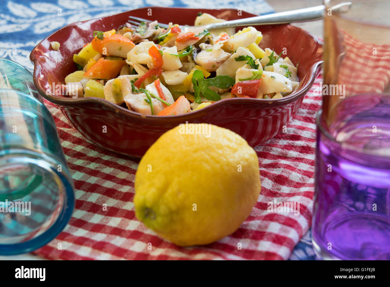 sea salad with vegetables and potatoes in a red tureen Stock Photo