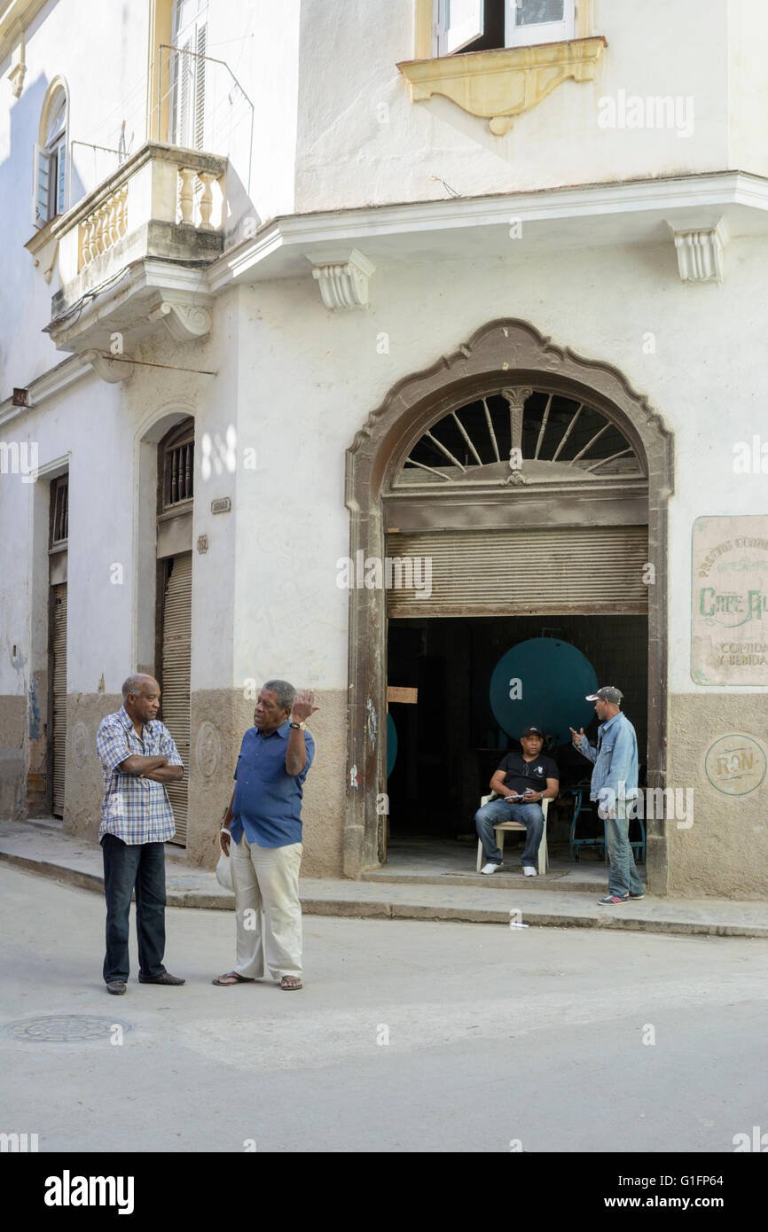 Local men exchange greetings outside Cafe Alma in Old Havana, Havana, Cuba Stock Photo