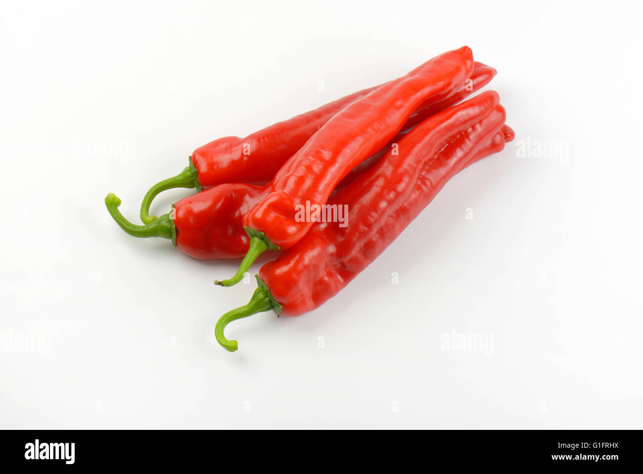 four red peppers on white background Stock Photo - Alamy