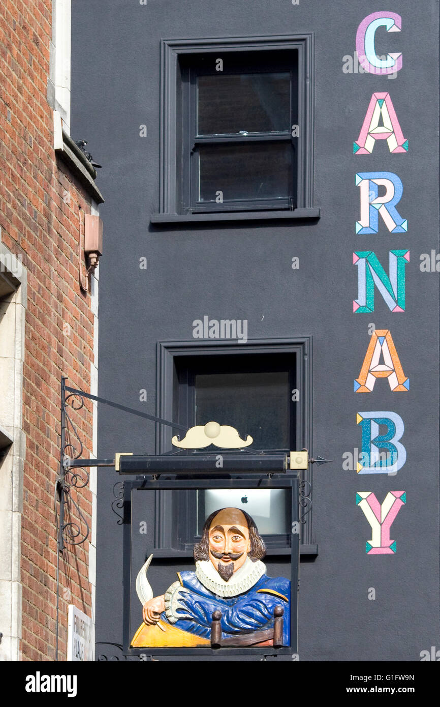 Carnaby painted in color on the side of a building behind the Shakespeare Pub sign Stock Photo