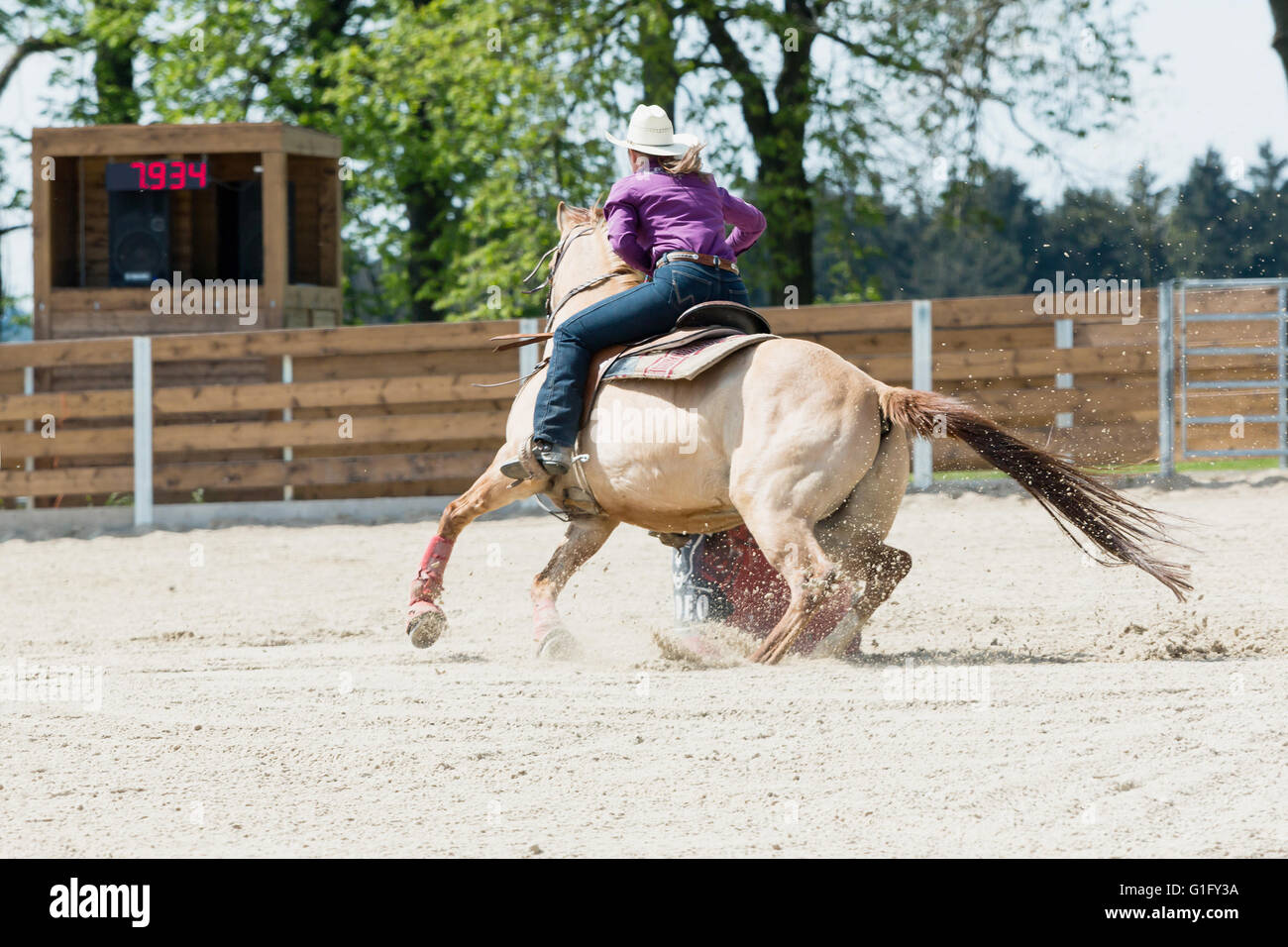 Young cowgirl with hat riding a beautiful paint horse in a barrel racing event at a rodeo in Mitrov, Czech republic Stock Photo