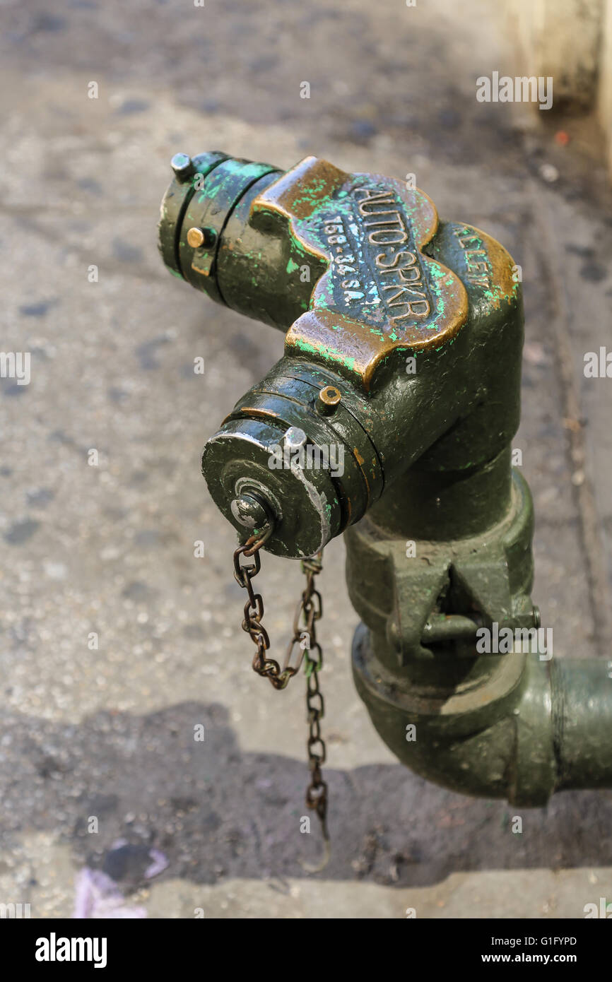standpipe extending from a NYC building unto the city sidewalk Stock Photo