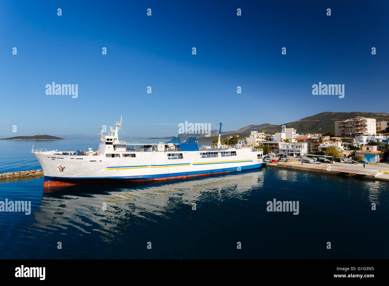 Marmari port with anchored ship against a blue sky and blue waters in Evia, Greece Stock Photo