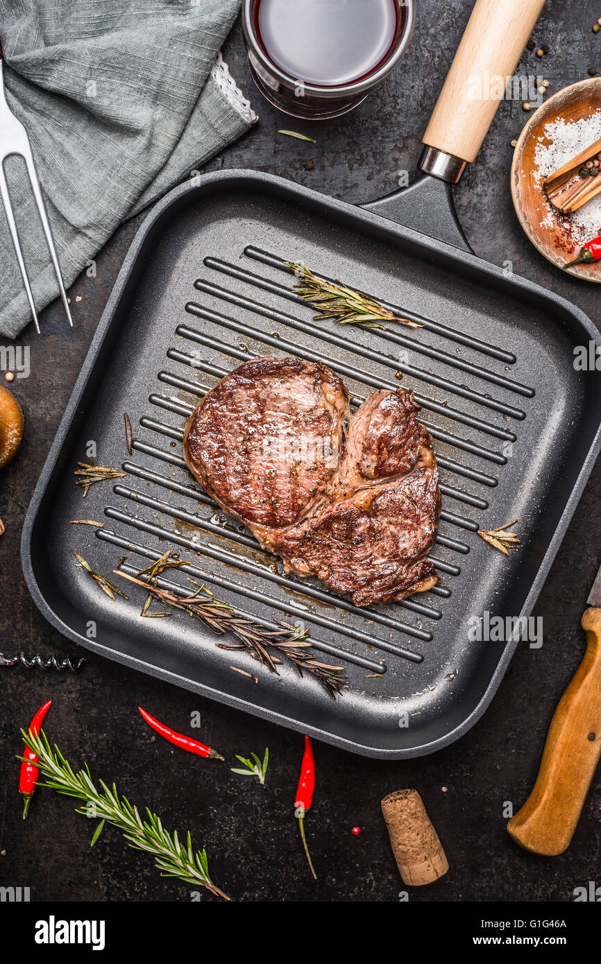 Grilled ribeye steak on grill iron pan on rustic kitchen background ...