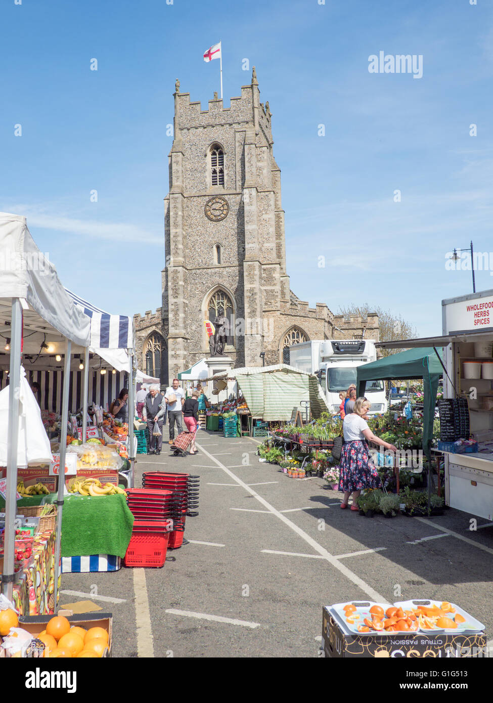 Sudbury's Market Hill on a Saturday, showing the local weekly market and St Peter's church in the background. Stock Photo