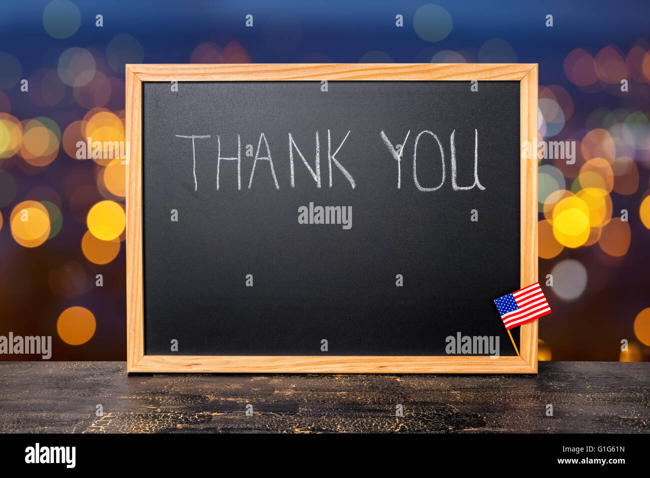 handwriting text thank you is written in chalkboard with flag on city ...