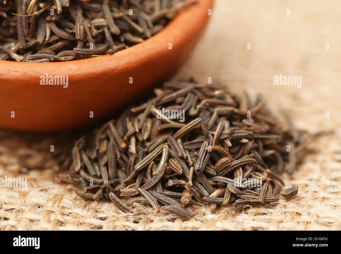 Caraway seeds in a bowl on jute Stock Photo
